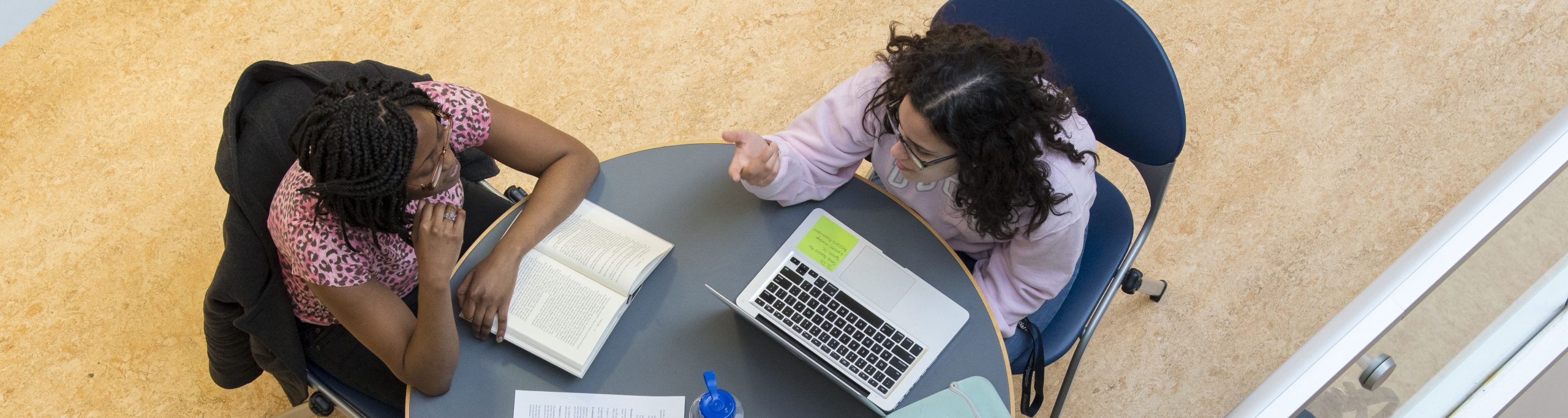 Three students studying at a table.